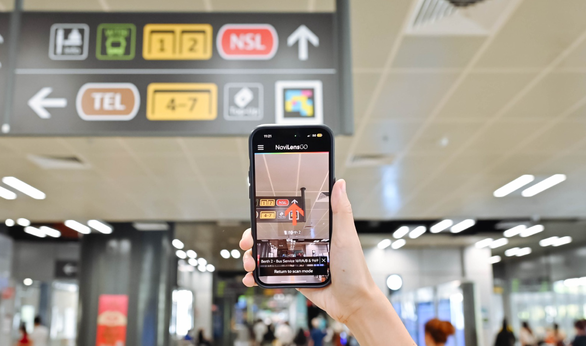 Fotografía de una persona navegando en la ciudad mientras escanea un código NaviLens con su teléfono