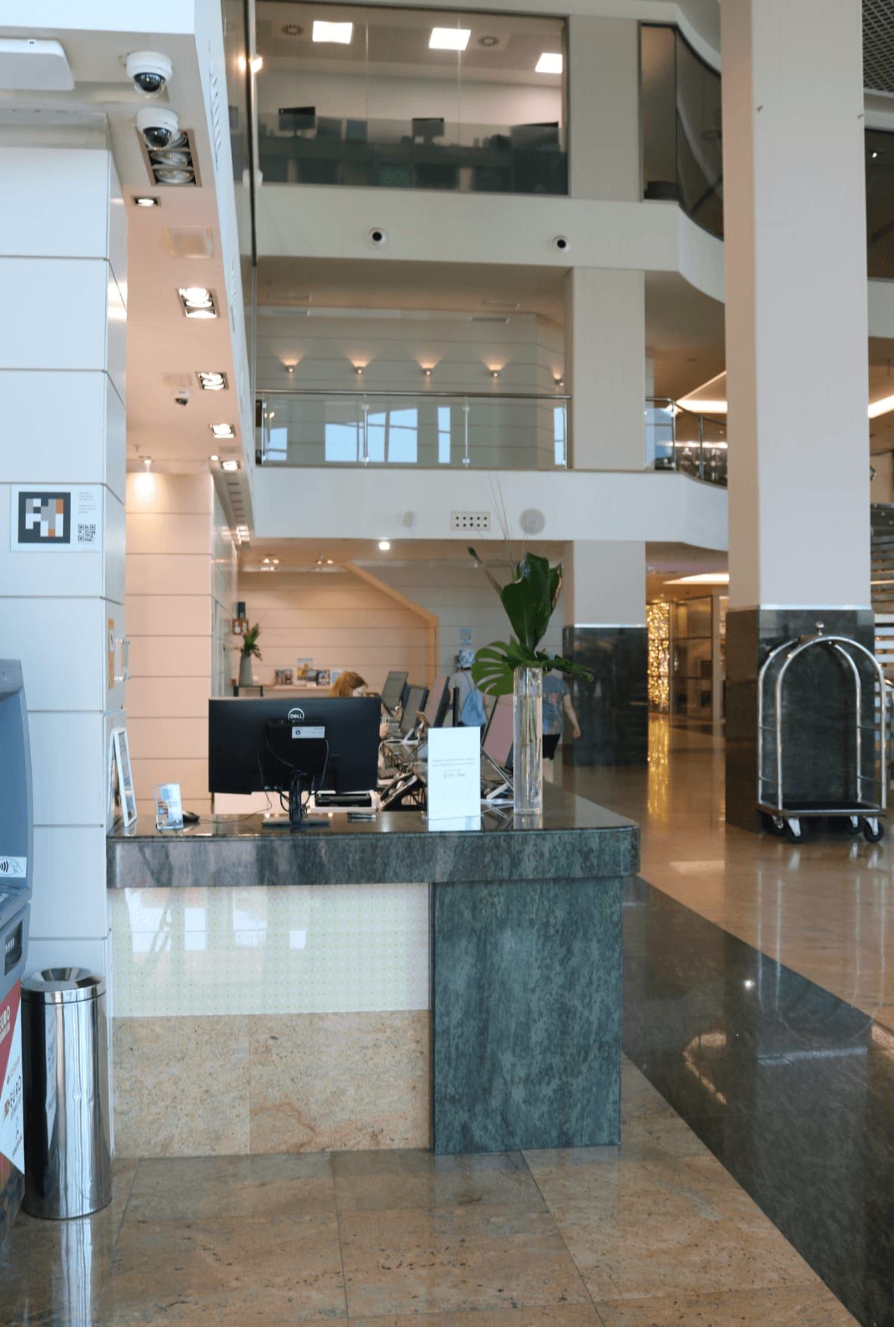 Recepción de un hotel con un código NaviLens visible en un pilar lateral.